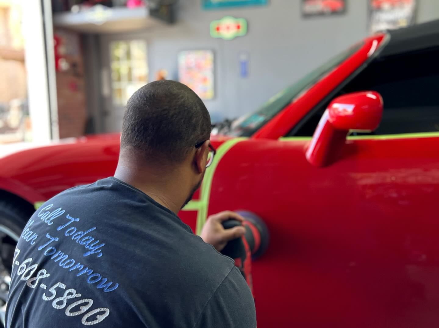 Detailer applying ceramic coating to a red car in the York, PA shop.