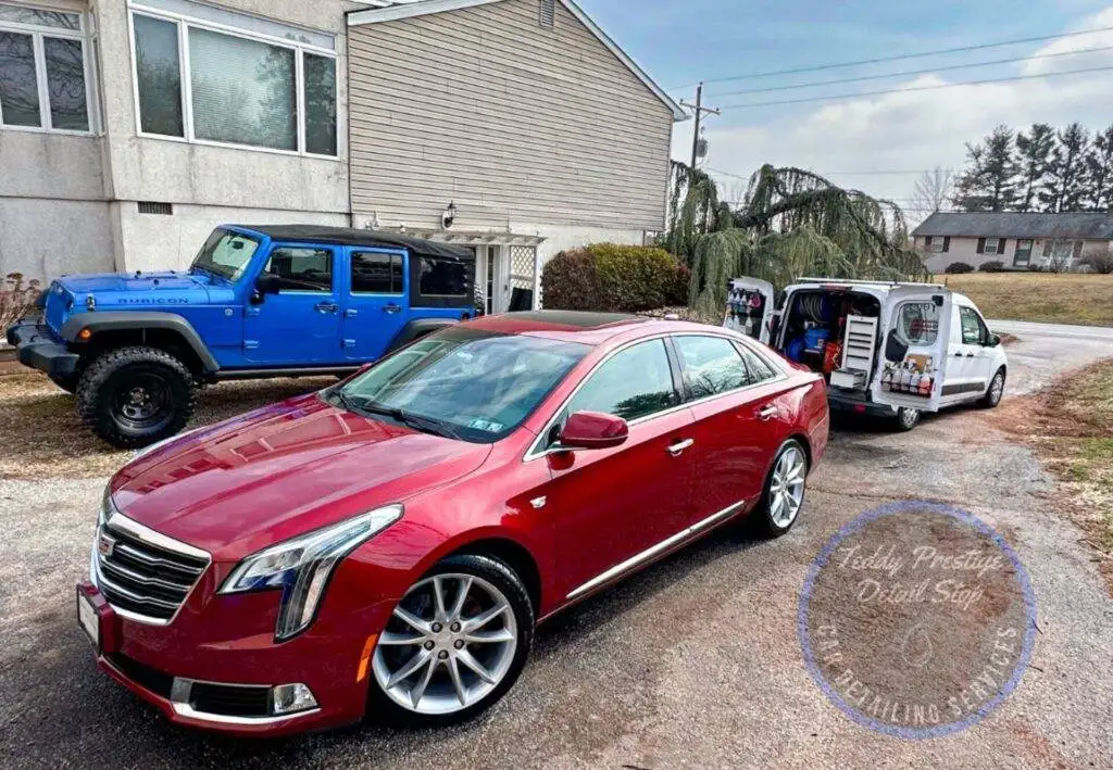Red sedan parked for commercial fleet detailing in York, PA, with service vans on-site (mobile detailing setup)
